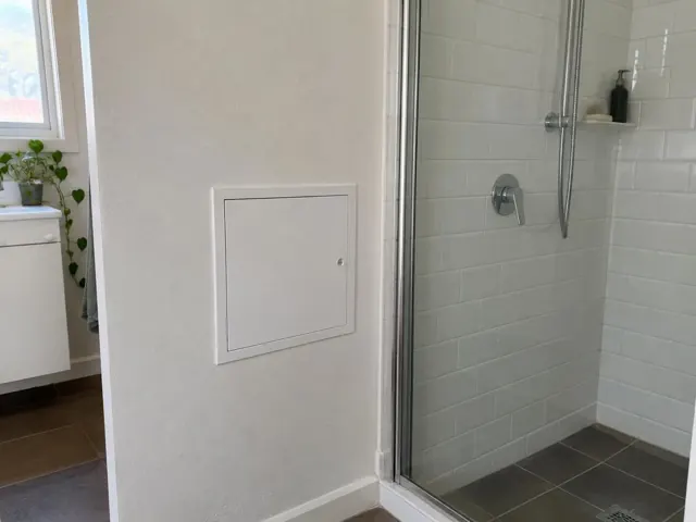 Small wall access panel beside a tiled shower and bathroom wall in Coogee